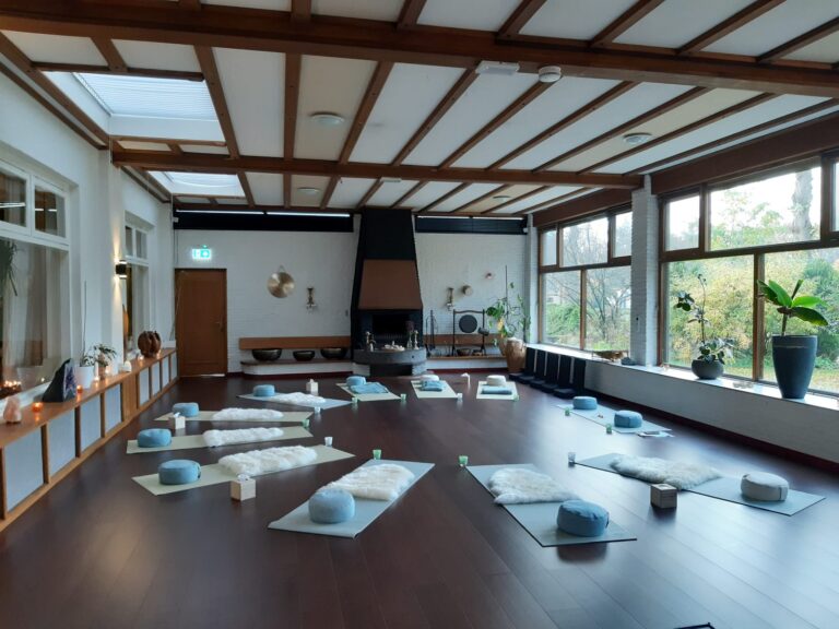 Yoga zaal met deelnemers op matjes in een cirkel